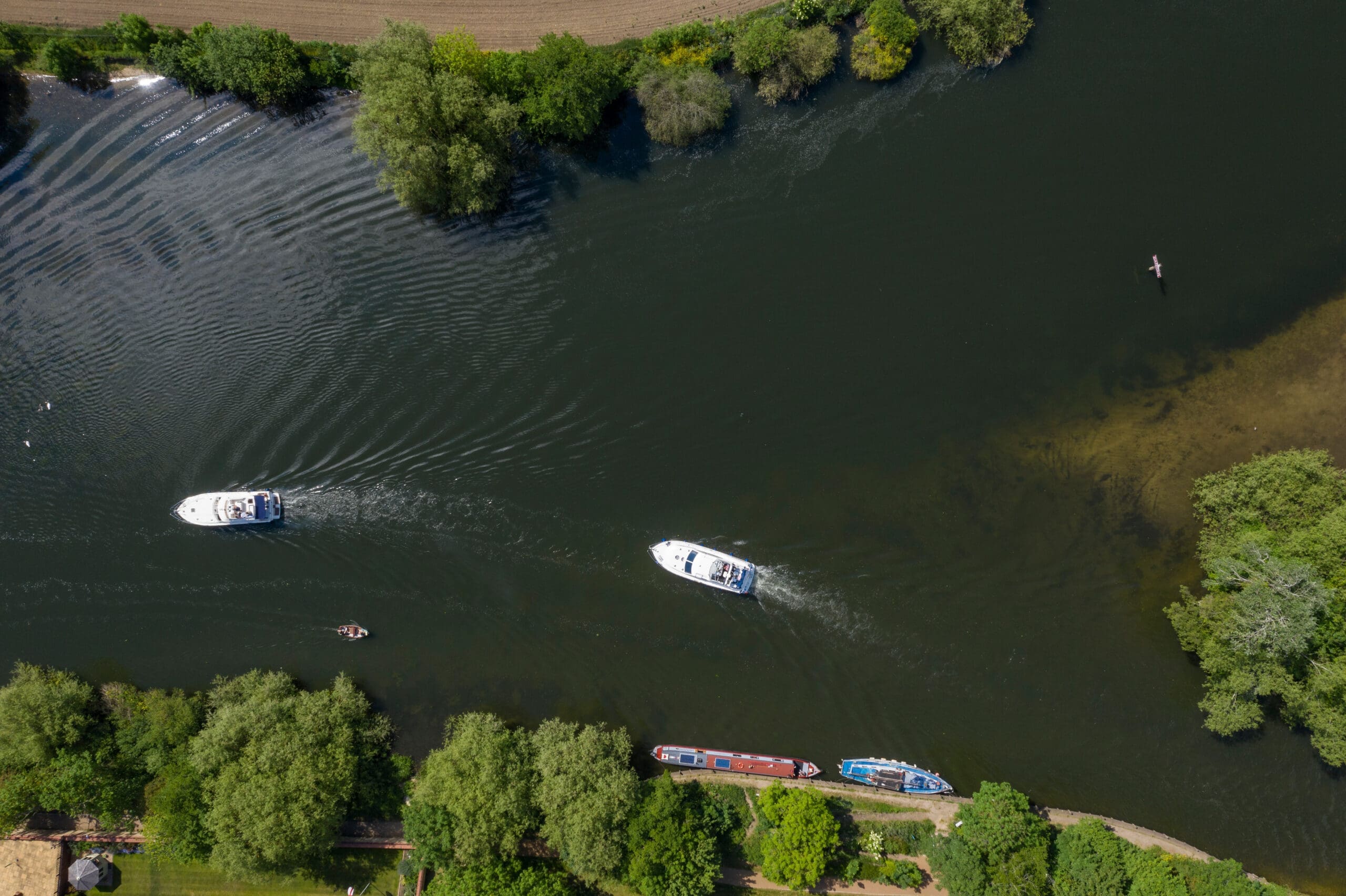 Overhead view of two boats and houses on the river Thames in Marlow, Buckinghamshire, office base for The Burnside Partnership in Marlow